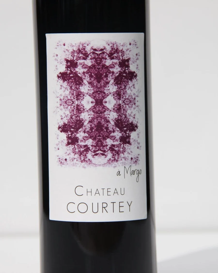 Une bouteille de Château Courtey, cuvée à Margo, son étiquette blanche marquée d'une empreinte pourpre
